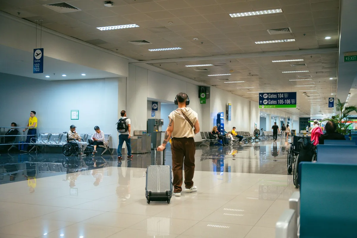 Passengers moving through a commercial airport terminal